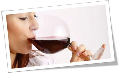 Mojas los labios en el rojo ardiente de la copa